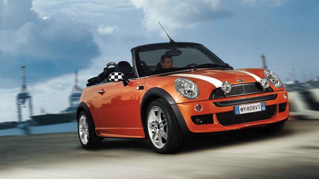 Perspectivă din faţă-dreapta a unui MINI Cabriolet, rulând pe timp de zi Perspectivă din faţă-dreapta a unui MINI Cabriolet, rulând pe timp de zi